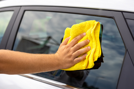 Man cleaning his car with a cloth