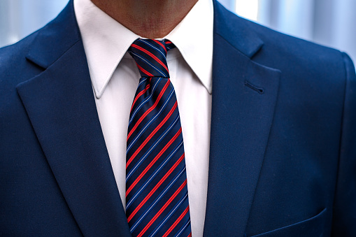 Man wearing a white shirt, tie and blue jacket close up, job