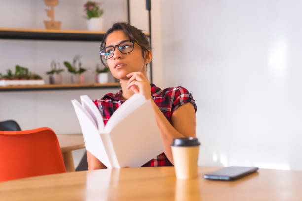 istock Pensive woman reading a book at home 1798215444