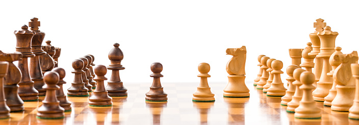 Chess pieces on a chessboard with white background
