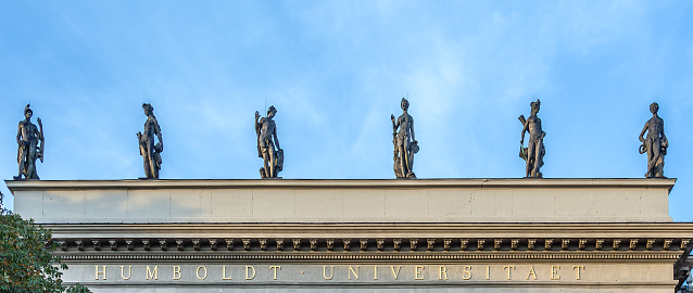 BERLIN, GERMANY - OCT 27, 2014: statue and facade of Humboldt university in Berlin, Germany. In 1810 Wilhelm von Humboldt founded the new type of university with the ideal of research and science.