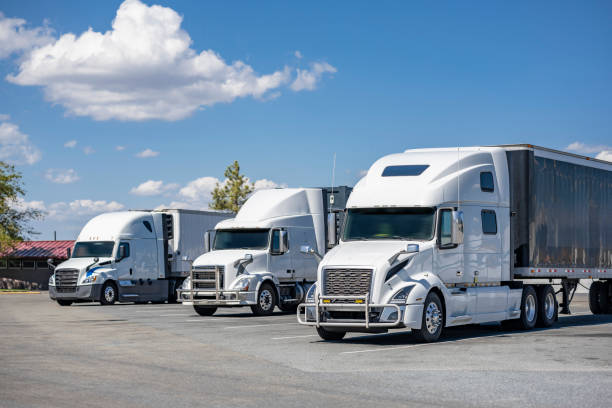 istock Three white big rig industrial semi trucks with semi trailers standing on rest area parking lot take a break 1798228271
