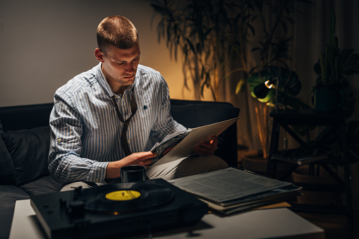 A Caucasian man is choosing a record at home