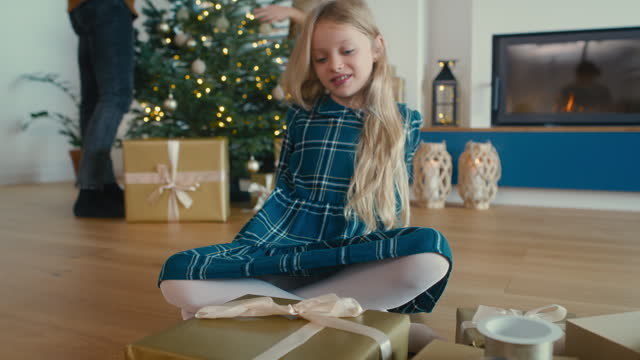 Caucasian girl wrapping Christian present on her own. Shot with RED helium camera in 8K.