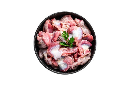 Raw uncooked chicken gizzards, stomach in a pan.  Isolated, white background
