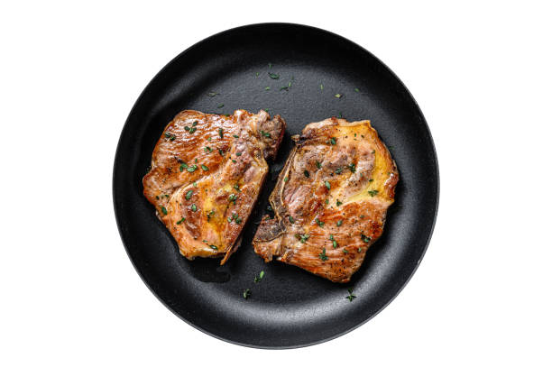 istock Fried pork loin steaks in a pan.  Isolated, white background. 1798268492