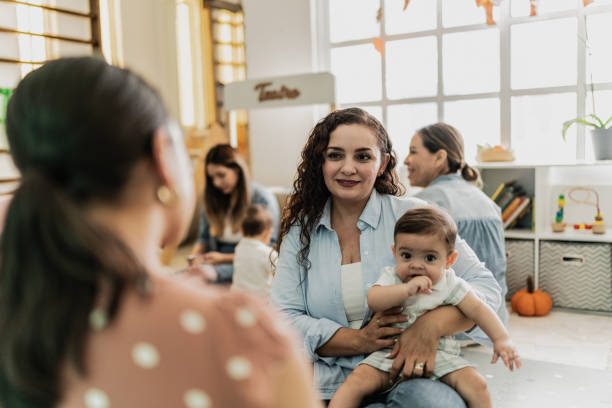Mother talking while holding her son in a support group at playroom