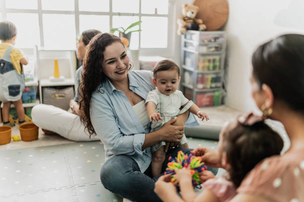 istock Mothers talking while playing with their babies in the playroom 1798282618