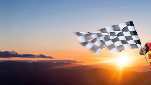 istock Checkered race flag in hand against sunset sky 1798297011