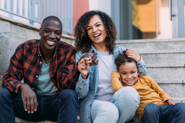 szczęśliwa młoda rodzina pokazuje klucze do swojego nowego domu. - common family new togetherness zdjęcia i obrazy z banku zdjęć