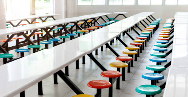 An empty classroom with long wooden desk