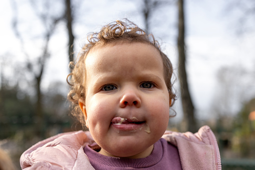 Waist-up shot of a young girl licking her lips in a public park looking into the camera. She is wearing warm clothing on a cold winter morning. The park is located in Gateshead.

Videos are also available for this scenario.