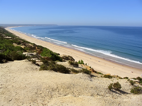 Fonte da Telha Beach in Costa da Caparica coast, with the Espichel Cape seen at the Atlantic Ocean horizon. Portugal