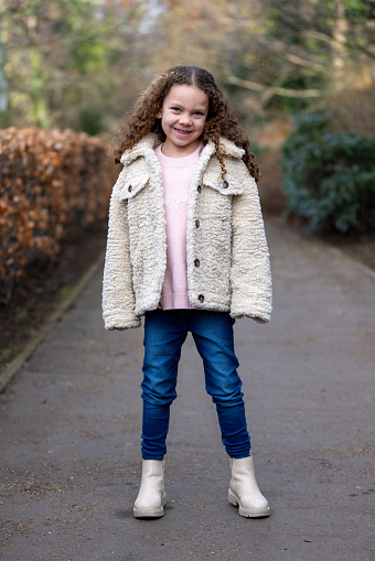 Full-length portrait of a young girl looking at the camera standing on a footpath in a public park. She is wearing warm casual clothing ready for a day out. The park is located in Gateshead.

Videos are also available for this scenario.