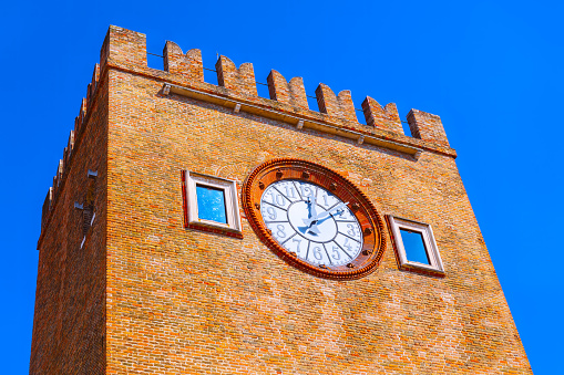 Venetian style tower made by red bricks with iconic clock