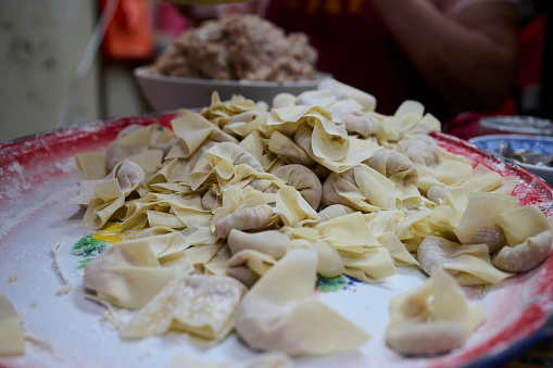 Woman hand made a wonton dumpling of traditional Chinese cuisine.