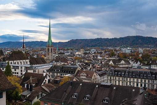 Rooftop view of old downtown Zurich city Switzerland. Autumn cloudy day, fall, Uetliberg hills in the background, no people.