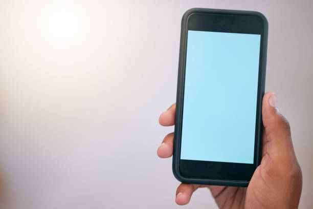 istock Unrecognizable person holding and using a phone in their hand at work. One nrecognizable person showing their phone screen and using social media alone 1798377511