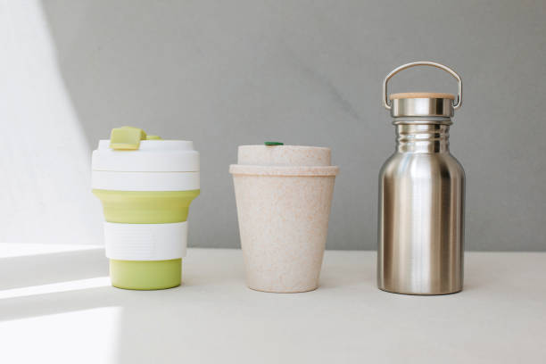 istock Devices for drinks. Zero waste concept. A tin bottle for water and two reusable mugs on beige background 1798387723