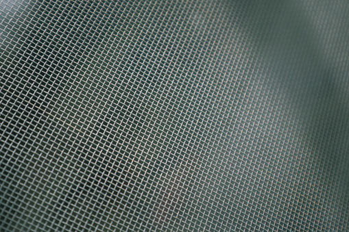 Image of a grey steel grill metal texture. Speaker grill texture. Perforated sheet metal. Gray technical background.