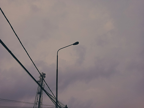 Cloudy sky background with street lights and towers.