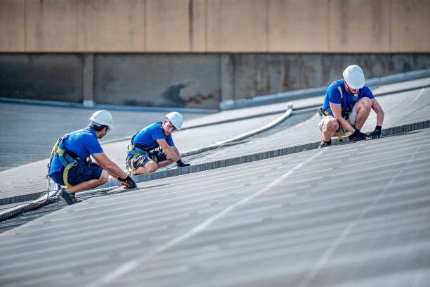 Team of three engineers installing solar panels Image of three workers Supervising a photovoltaic installation in a factory builing Industrial Roofing stock pictures, royalty-free photos & images