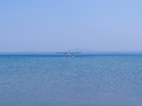 Seaplane in the sea. Seaplane docking at the pier in a bay in Bozcaada in the Northern Aegean, Turkey. Summer. No people.