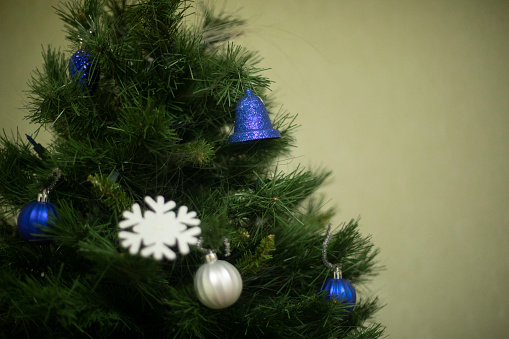 Christmas decorations on a tree. Christmas Tree. Blue Toys on Branches. Interior details for a holiday.