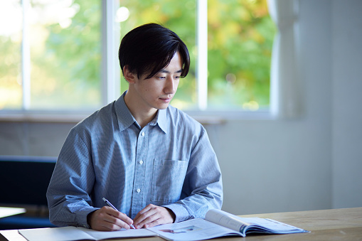 Japanese male university student studying in the living room