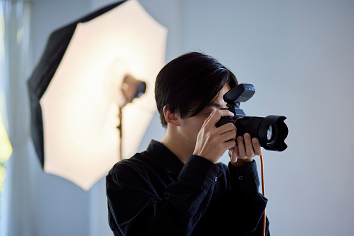 Japanese male photographer working in a photo studio