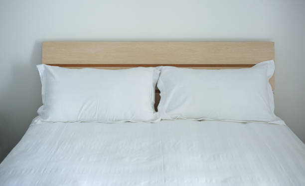 istock Group of two white pillows on a bed with headboard 1798437960