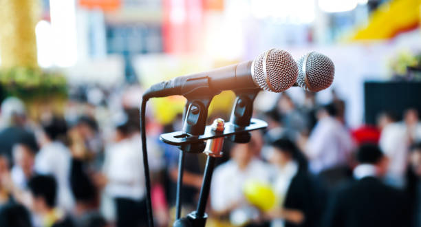 istock Closeup microphone in auditorium with blurred people in the background 1798437995
