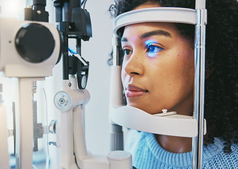 Ophthalmology, medical and eye exam with black woman and consulting for vision, healthcare and glaucoma check. Laser, light and innovation with face of patient and machine for scanning and optometry