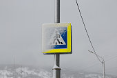 Pedestrian walkway sign covered with snow