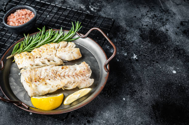 istock Roast Fillets of codfish, cooked cod fish meat. Black background. Top view. Copy space 1798442504