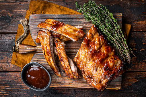 Grilled pork Baby Back spare ribs on a wooden board. Wooden background. Top view.