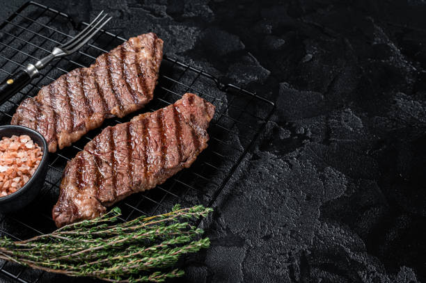 istock Grilled denver beef meat steak on a rack. Black background. Top view. Copy space 1798449099