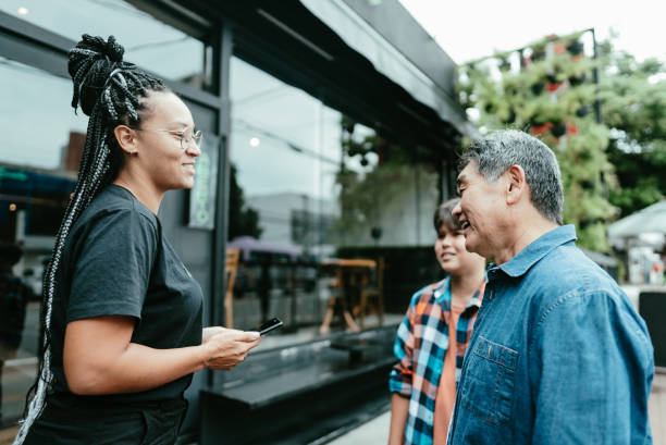 istock Father and son talking with receptionist of the restaurant 1798477565