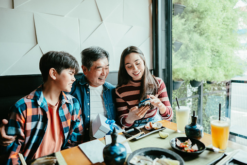 Family looking something on mobile phone at restaurant