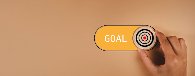 Target goal success and business objective focus on grow concept. Hand switch Target with arrow icon to goal excellence on orange background , Business plan purpose challenge.