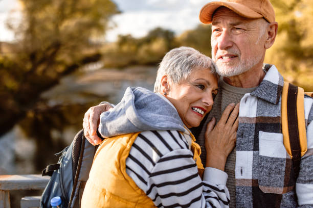 istock Senior hikers hugging on bridge over beautiful river 1798491740