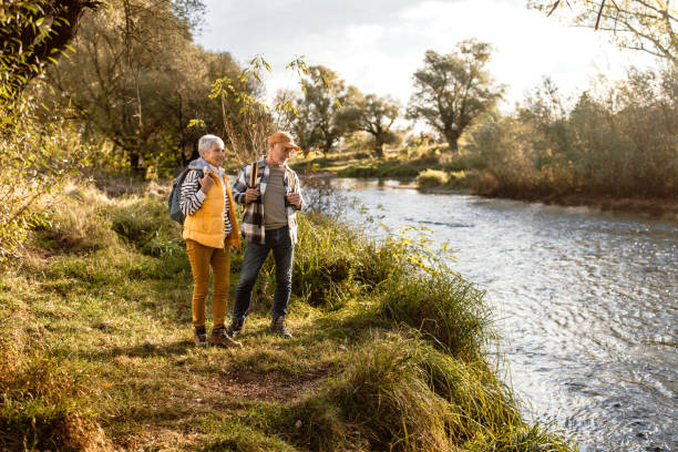 istock Senior hikers enjoying walk by the river on a sunny autumn day 1798496155