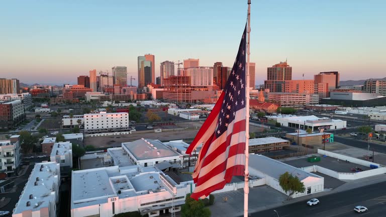 American flag waving at sunset in Phoenix, Arizona. Cinematic aerial orbit of United States pride.