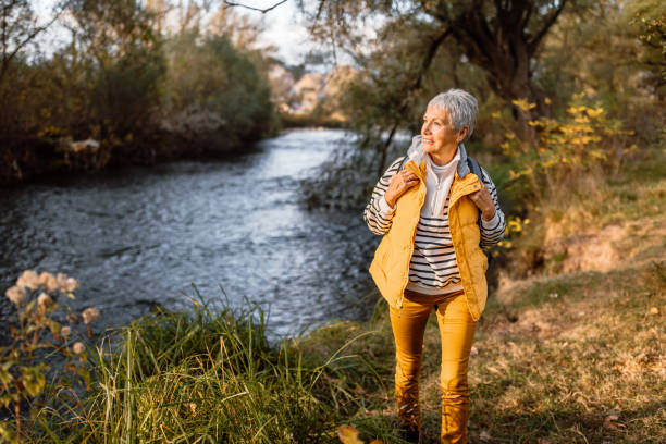 istock Senior man with backpack walking by the river on autumn day 1798522210