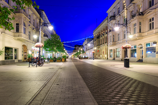 Lodz, Poland - August 24, 2023: Beautiful architecture of Piotrkowska Street in Lodz city at dawn, one of the longest commercial thoroughfares in Europe, with a length of around 4.2 km. Poland