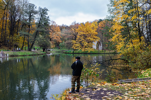 Moscow, Russia – October 21, 2023: Autumn in the park. a man fishing on the lake