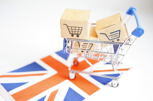 Online shopping, Shopping cart box on United Kingdom flag, import export, finance commerce.