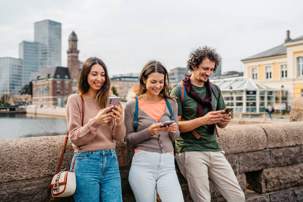 istock Three Young Friends Using Their Phones On The Bridge In Malmo In Sweden 1798563014