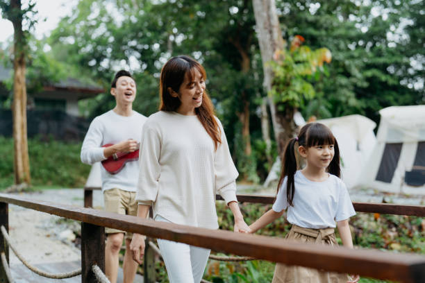 istock Happy family holding hands while walking in the campsite 1798592609