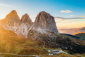 Aerial View of Paradise Sunset Over Mountain Layers and Hairpin Road of Sella Pass in Dolomites Alps